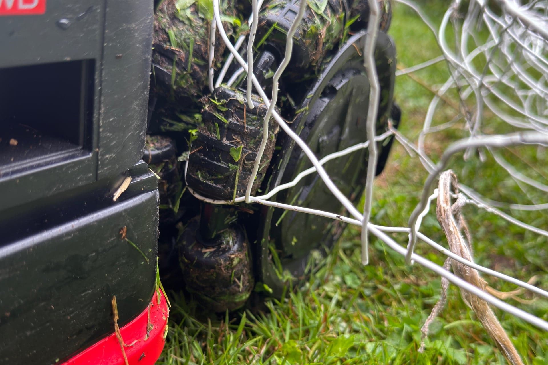 Dreame A3 AWD Pro 3500 with an omnidirectional wheel caught on a wire fence — © Wes Davis / Gizmodo