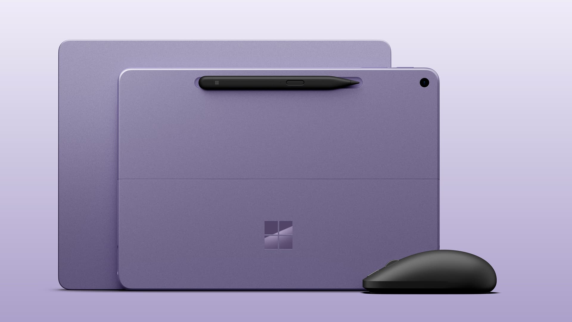 Microsoft Surface Laptop 13-inch next to Surface Laptop 12-inch, both in violet colorway next to the new black Surface Mouse. — Both Surface Laptop 13-inch and Surface Pro 12-inch 2nd Editions come in the Violet colorway with the optional new Surface Mouse. Image credit: Microsoft