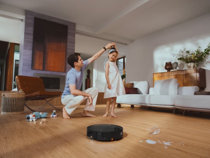 Saros 20 Flow cleaning in a living room with people. — The Saros 20 Flow includes obstacle avoidance and a self-maintenance dock.