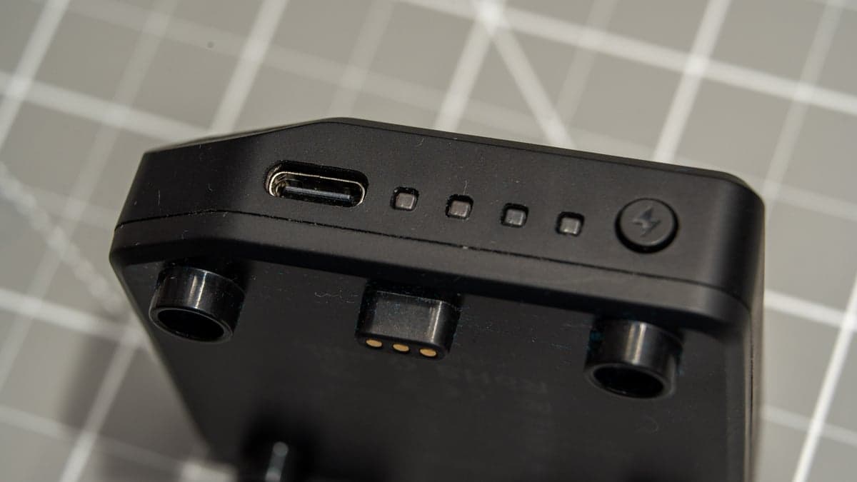 The detachable 3,000mAh lithium-ion battery pack showing its dedicated USB-C port, four-stage LED charge gauge, and status check button